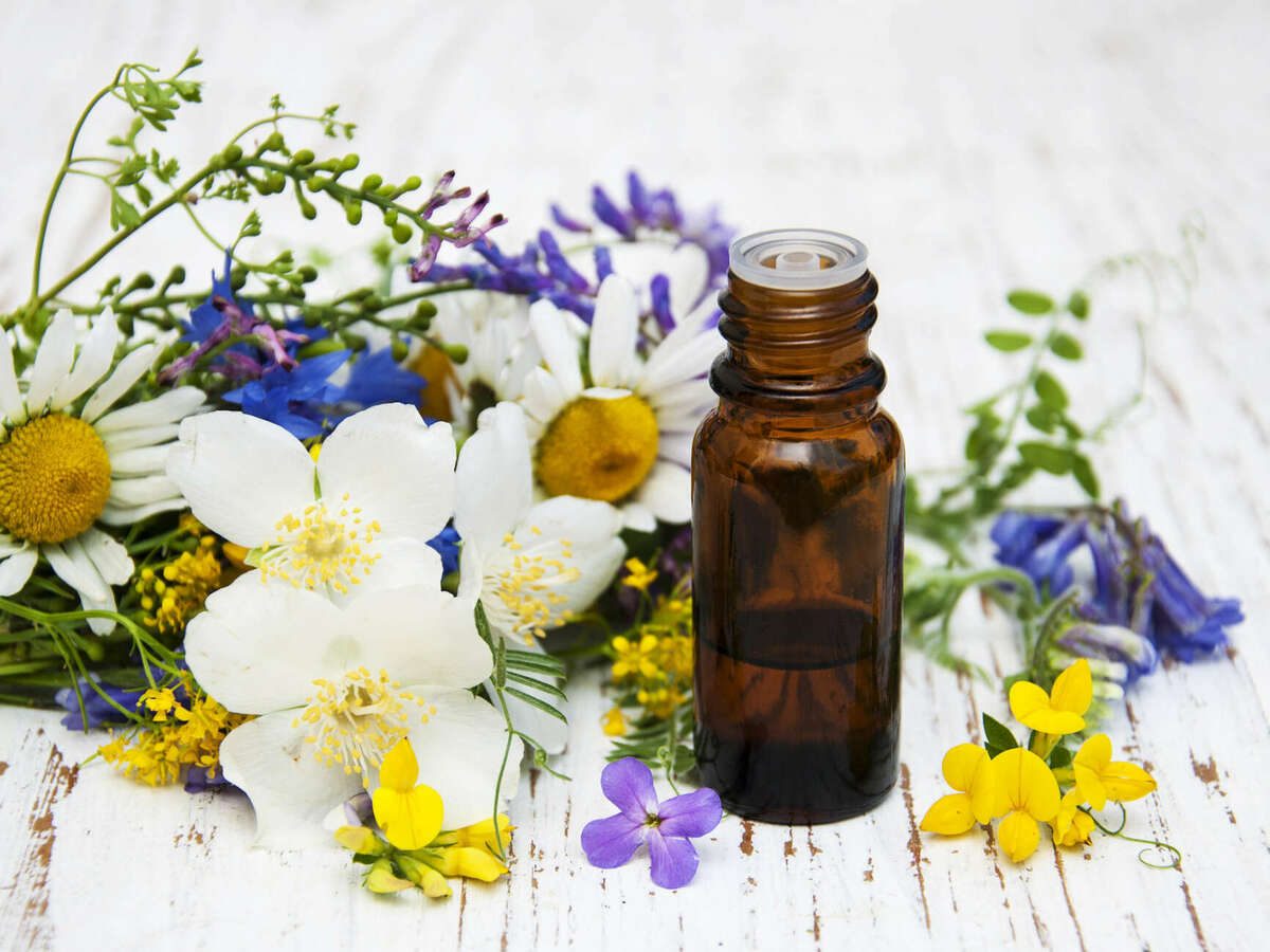 Flacon d'huile essentielle et fleurs des champs